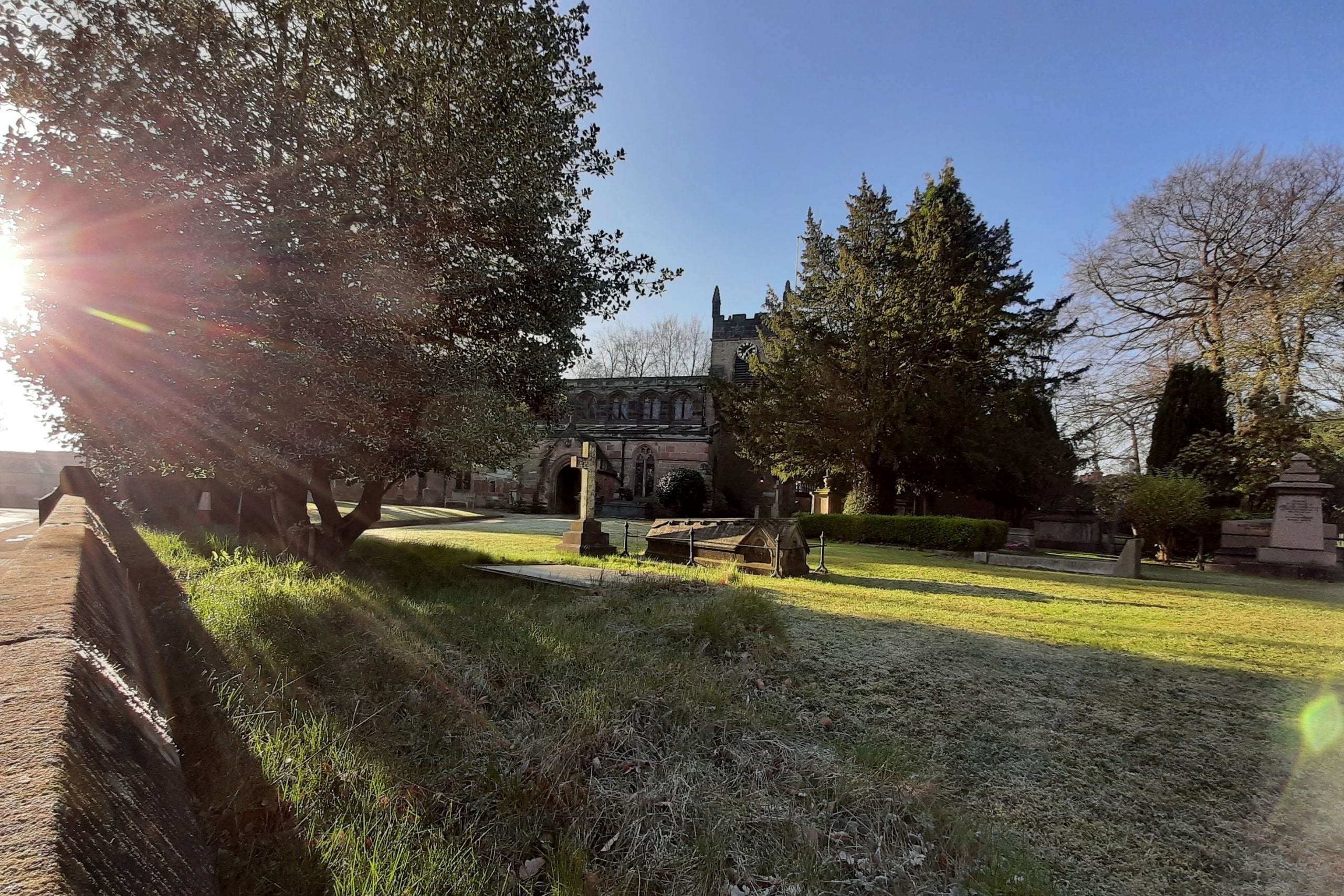 Sunlight through the trees in the churchyard